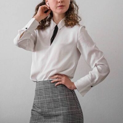 A business woman posing in a studio with white wall in a background